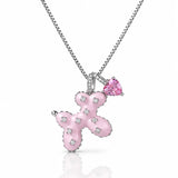 A silver-tone box chain necklace featuring a pink enamel balloon pendant embellished with small clear stones, and a dangling pink heart-shaped gemstone charm, shown on a white background with a soft reflection.