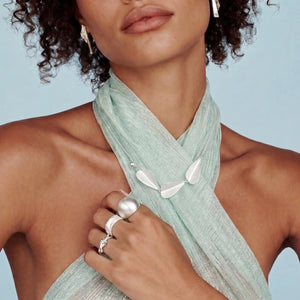 Woman wearing a light green scarf with a plain background
