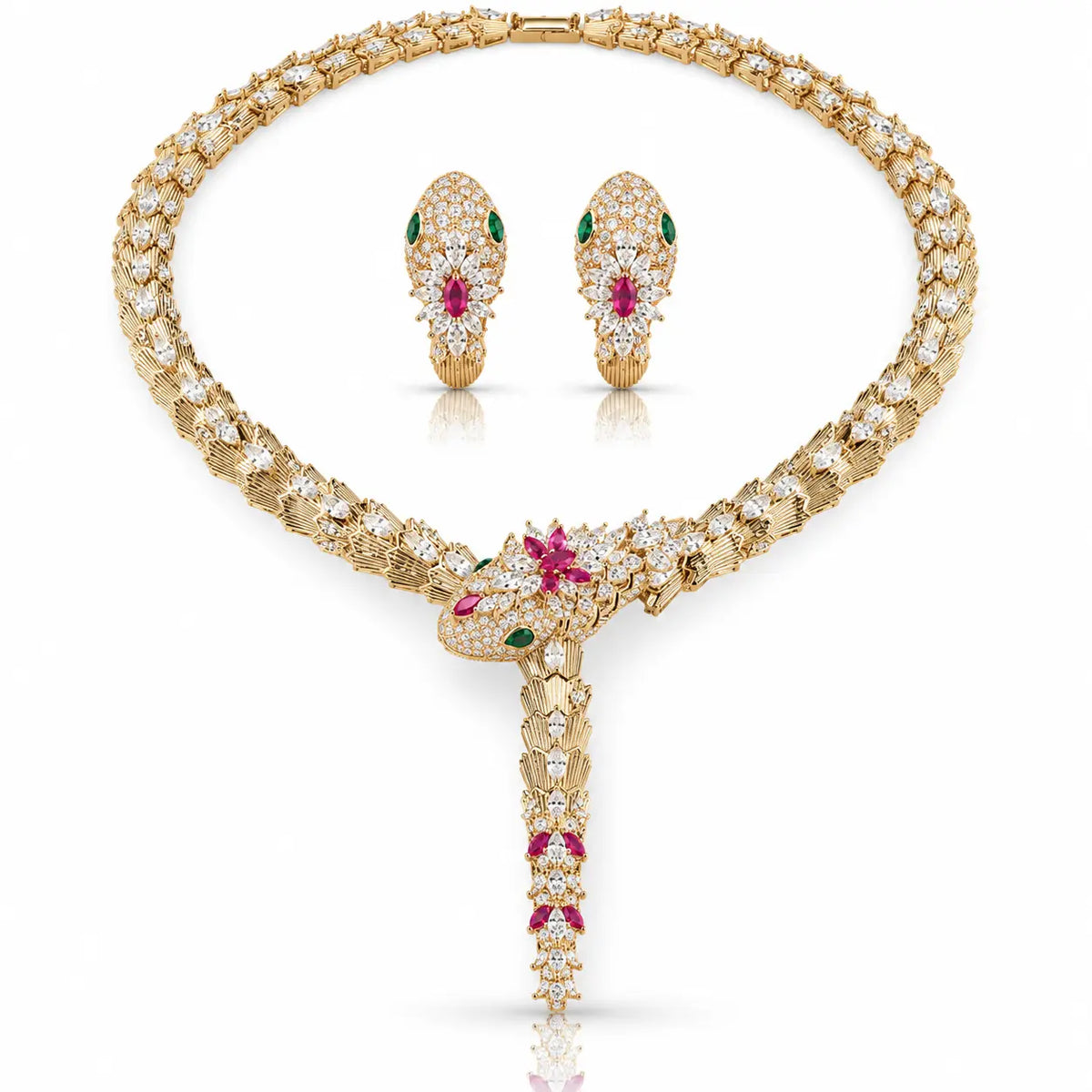 A luxury gold jewelry set featuring a snake-head pendant necklace and matching snake-head earrings, both heavily embellished with clear pavé diamonds and accented with green emerald-cut gemstones and pink ruby-cut gemstones, displayed on a clean white background.