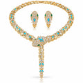 Gold jewelry set featuring a snake-head necklace and matching drop earrings, embellished with clear pavé stones, turquoise blue stones, and small green stones, displayed on a white background.
