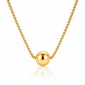 A gold box chain necklace with a polished spherical bead pendant, displayed against a clean white background with a soft reflection below.