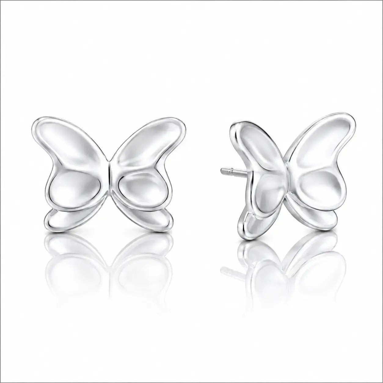 A pair of silver butterfly stud earrings shown on a clean white background with soft reflections below. One earring is facing forward and the other is angled to show the side profile and post.