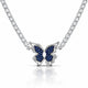 A silver-tone butterfly pendant necklace featuring dark blue pavé-set wings and a clear central stone, suspended from a sparkling silver chain on a white background with a soft reflection.