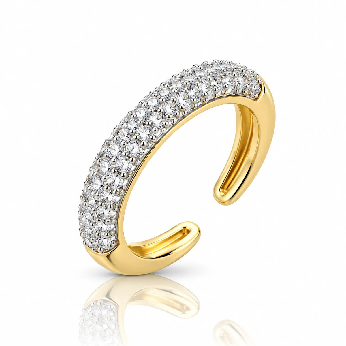 A pair of gold huggie hoop earrings set with clear pavé gemstones on a clean white background with a soft reflection below.