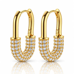 A pair of gold hoop earrings with curved, shield-like U-shaped fronts paved with clear cubic zirconia stones, shown on a white background with a soft reflection below.