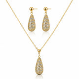 Gold jewelry set featuring a teardrop-shaped pendant necklace and matching drop earrings, both adorned with pavé-set clear stones on a white background.