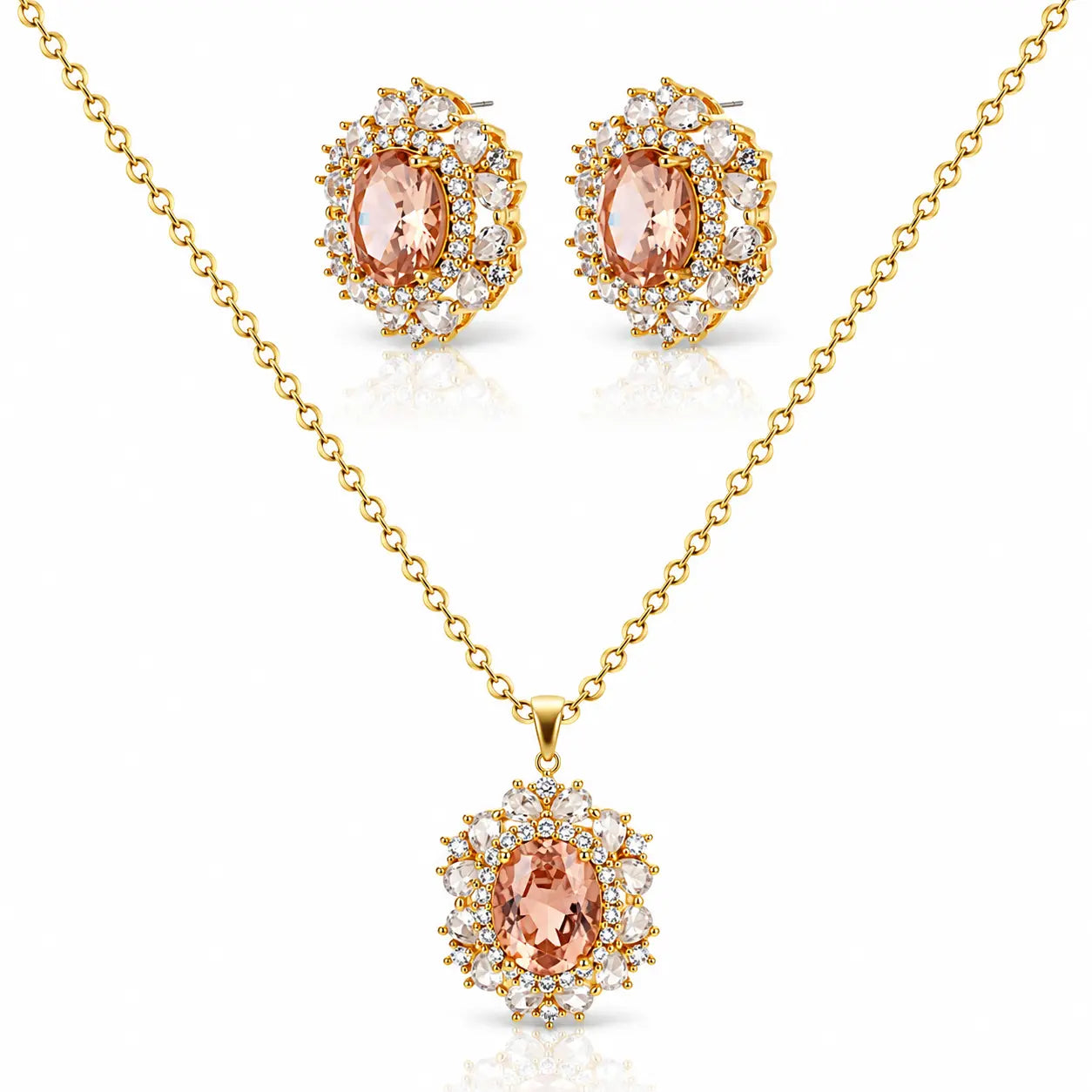 Gold jewelry set featuring a pendant necklace and matching stud earrings with oval peach-pink center stones surrounded by clear crystals on a white background.