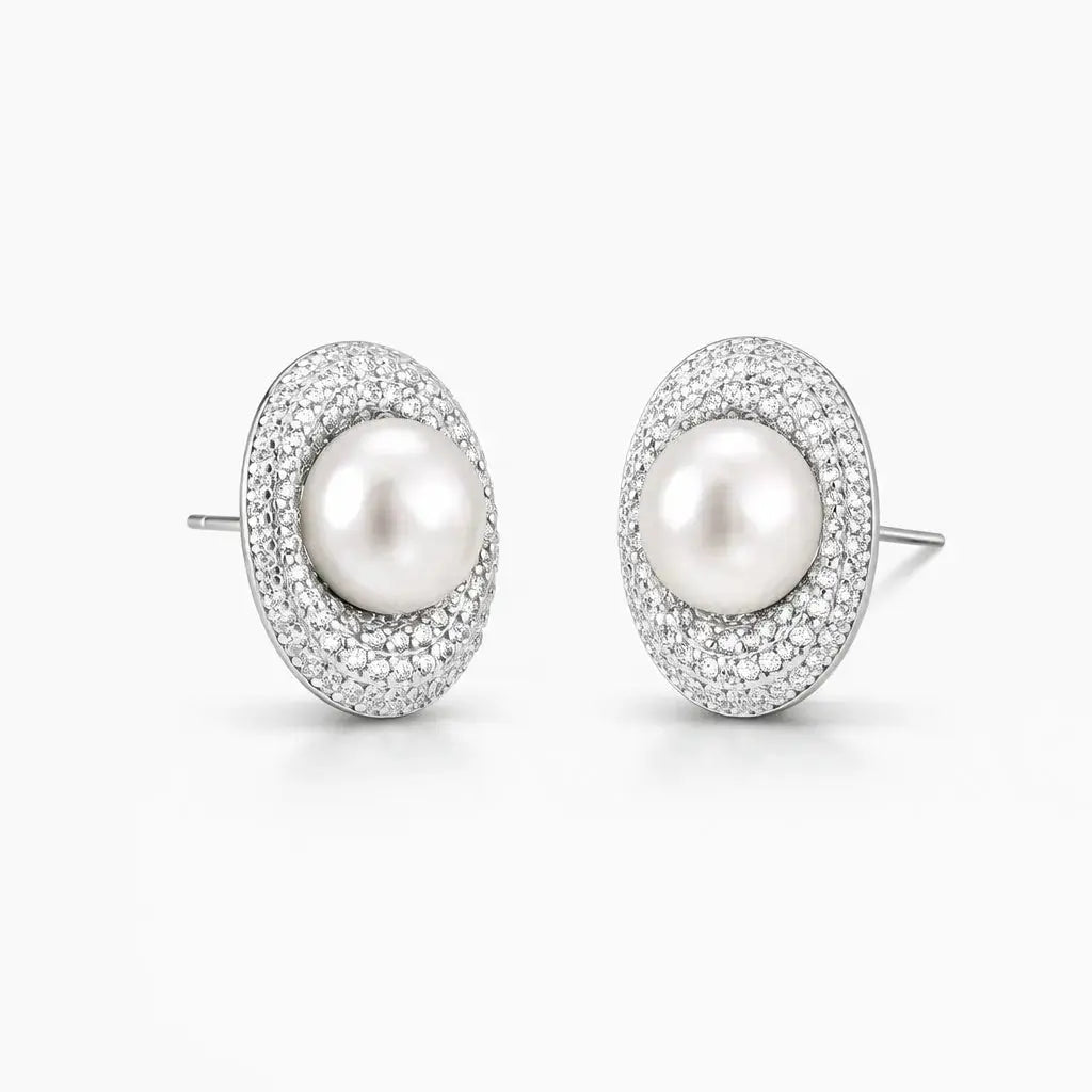 Oval pearl stud earrings with sparkling pavé crystal halo on white background