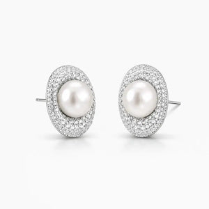Oval pearl stud earrings with sparkling pavé crystal halo on white background