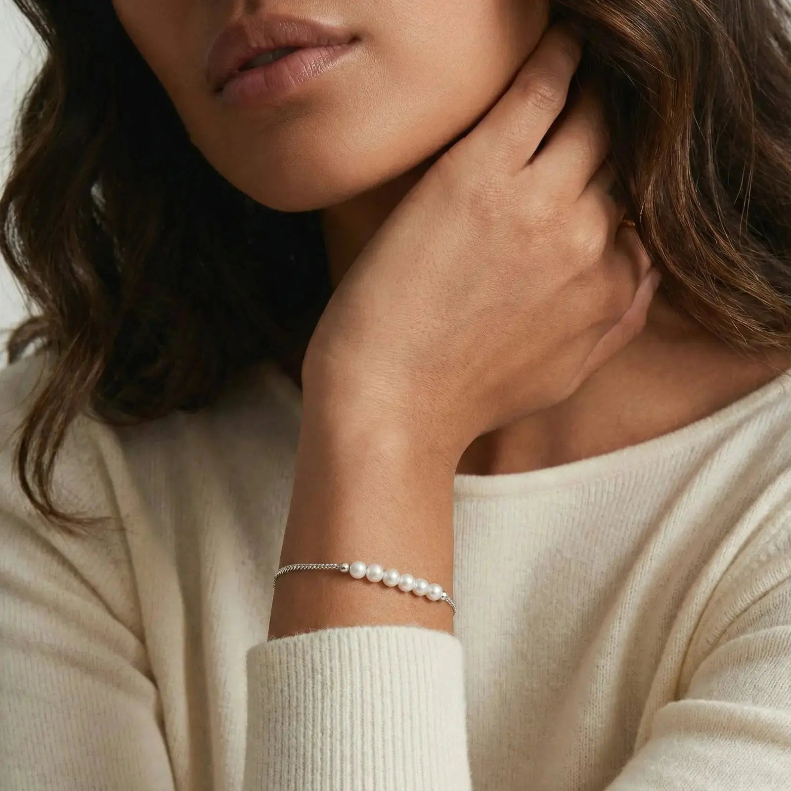 Woman wearing a rhodium 925 silver pearl line bracelet on wrist, elegant jewelry