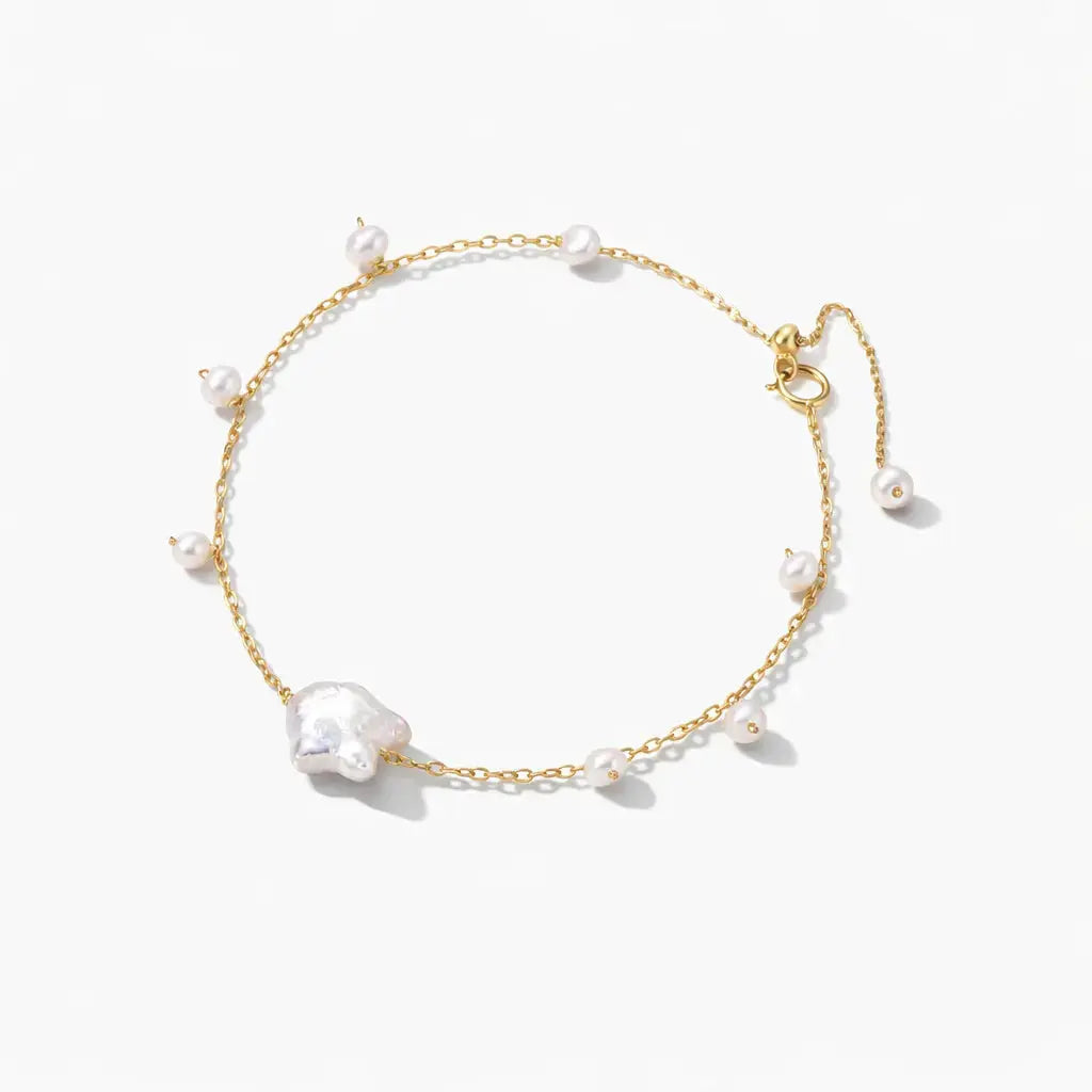 Delicate gold chain bracelet with white freshwater pearls on a white background