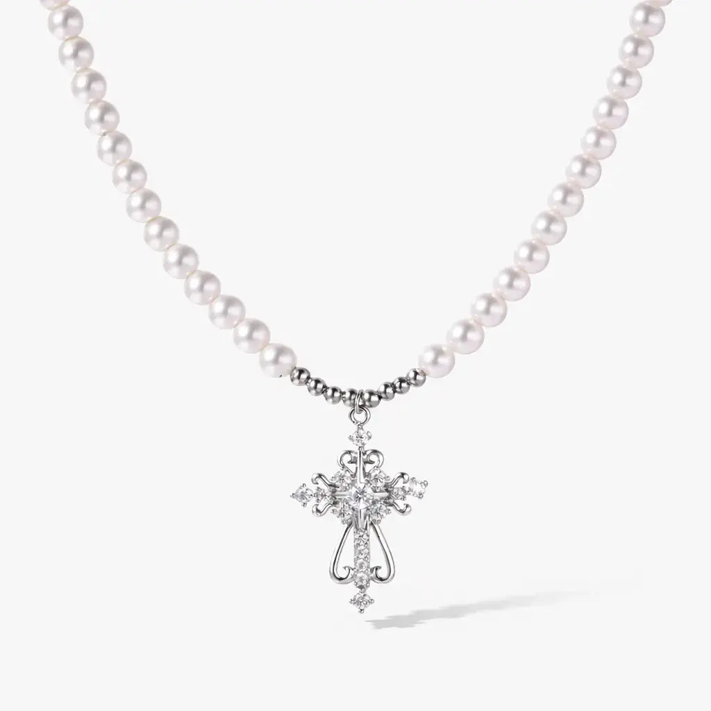 White gold cross pendant on pearl necklace, elegant jewelry on white background