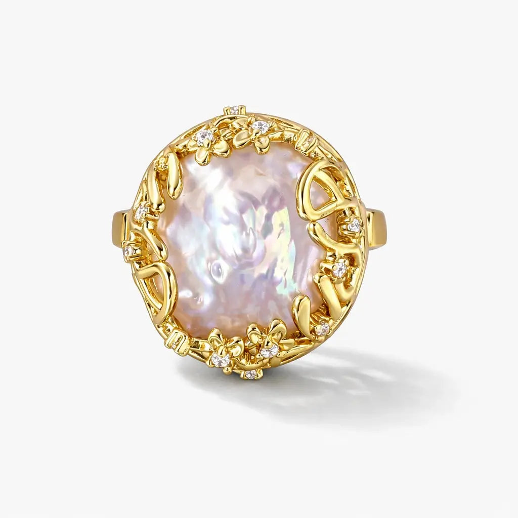 14K gold ring with large baroque pearl and floral diamond accents on a white background