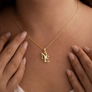 Gold necklace with a pendant on a person's neck, hands gently touching the skin.