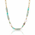 A gold chain necklace featuring green amazonite cylindrical beads, turquoise and white beads, and a large white baroque pearl, displayed on a clean white background with a soft reflection.
