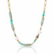A gold chain necklace featuring green amazonite cylindrical beads, turquoise and white beads, and a large white baroque pearl, displayed on a clean white background with a soft reflection.