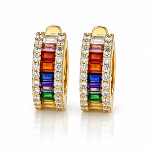 A pair of gold huggie hoop earrings featuring a vibrant rainbow channel set with baguette-cut gemstones and rows of clear round stones, shown on a reflective white background.