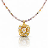 Gold pendant necklace with multicolored beads on a white background