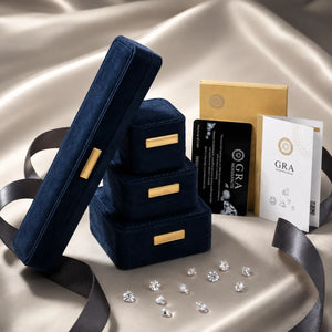 Set of blue velvet jewelry boxes with gold accents on a beige fabric background