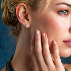 Close-up of a woman wearing a diamond earring with a blue background