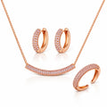 Rose gold jewelry set featuring a necklace with a pavé curved bar pendant, matching pavé hoop earrings, and a pavé open cuff ring, displayed on a clean white background.