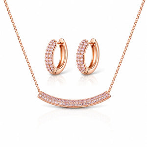 Rose gold jewelry set featuring a curved bar necklace and matching hoop earrings, both adorned with rows of small clear pavé stones, shown on a white background with soft reflections.