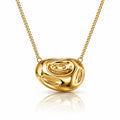 A polished yellow gold abstract pendant necklace with a textured, organic shape, suspended from a matching gold chain on a clean white background with a soft reflection below.