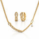 Gold jewelry set featuring a curved bar necklace, matching huggie hoop earrings, and a small dangling charm, all adorned with clear stones on a white background.