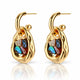 A pair of gold huggie hoop earrings with abstract organic-shaped gold bodies and colorful iridescent inlay stones, shown on a clean white background with a soft reflection below.
