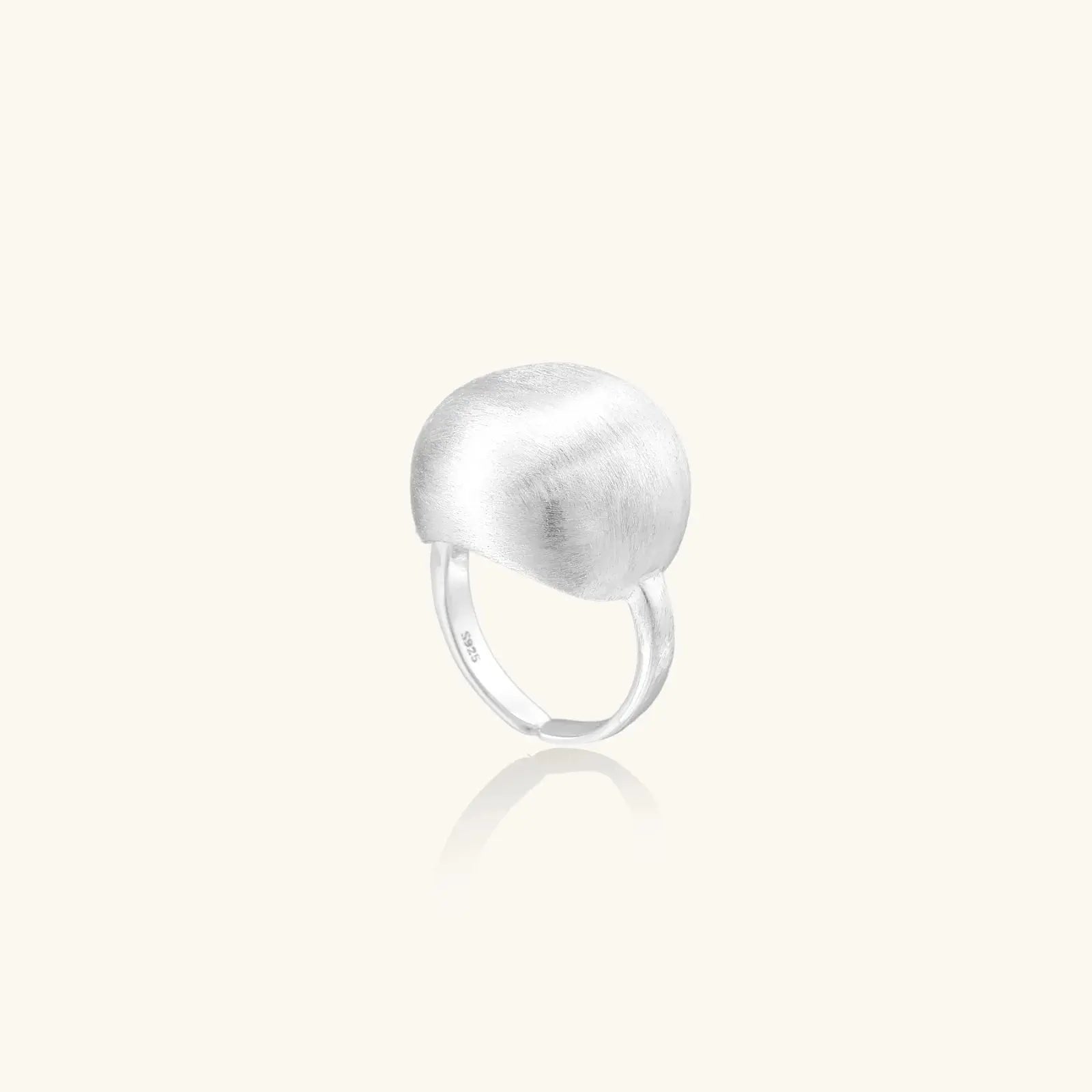Silver ring with a textured ball design on a white background