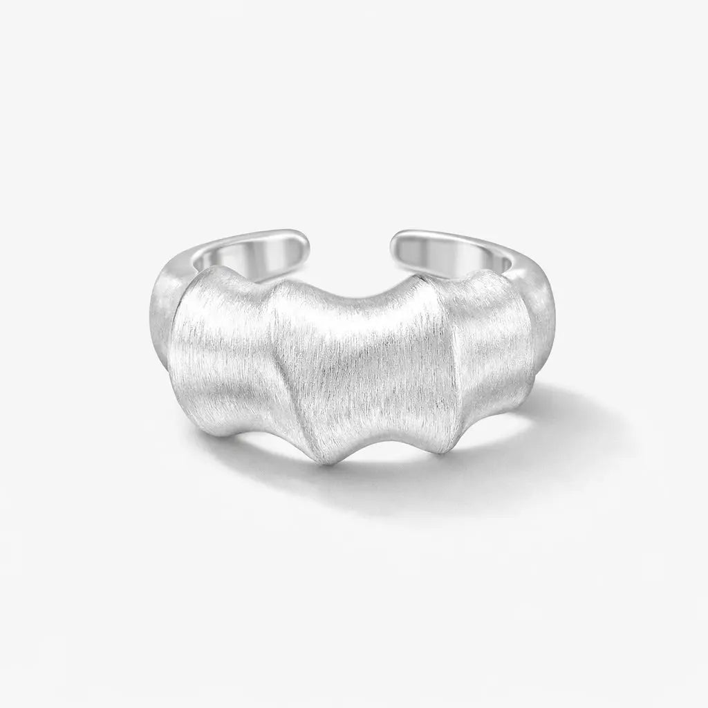 Textured sterling silver wave ring with open adjustable band on a white background