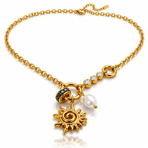 A gold chain necklace with a sun pendant, a white pearl bead, a black and gold beaded accent, and clear rhinestone details, shown on a white background.