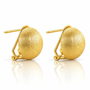 A pair of gold stud earrings with a textured, spherical dome design and a geometric wire frame setting, shown on a reflective white surface.