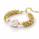 A gold-toned beaded bracelet featuring a large, irregular white baroque pearl and smaller smooth white pearls, displayed on a clean white background.