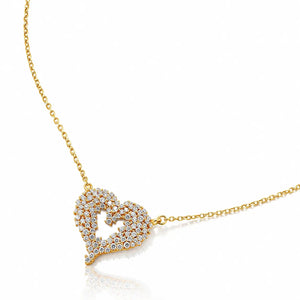 A gold heart-shaped pendant necklace paved with small clear stones, shown on a clean white background with a soft reflection below.