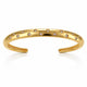 A polished gold open cuff bracelet decorated with small star-shaped settings holding clear round stones, shown on a clean white background with a soft reflection below.