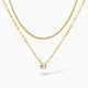 Layered gold necklaces with a solitaire crystal pendant on a white background