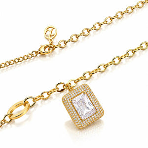 A gold chain necklace with a rectangular halo pendant featuring a clear emerald-cut center stone surrounded by small clear stones, shown on a white background.