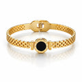 Gold bracelet with a black center on a white background