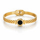 Gold bracelet with a black center on a white background