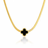 Gold necklace with a black clover-shaped pendant on a white background
