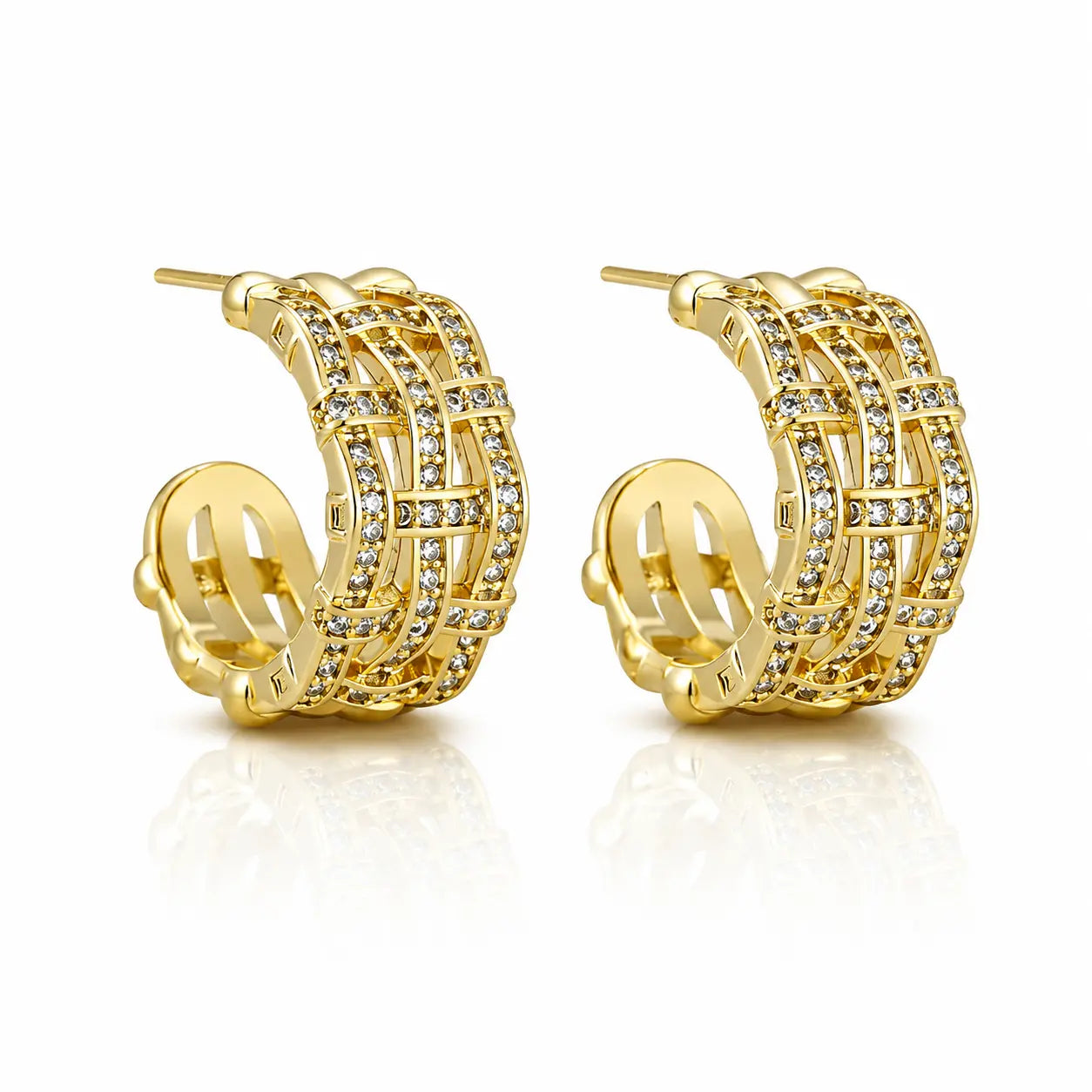 A pair of gold huggie hoop earrings adorned with multiple rows of clear pavé-set cubic zirconia stones, displayed on a clean white background with a soft reflection.