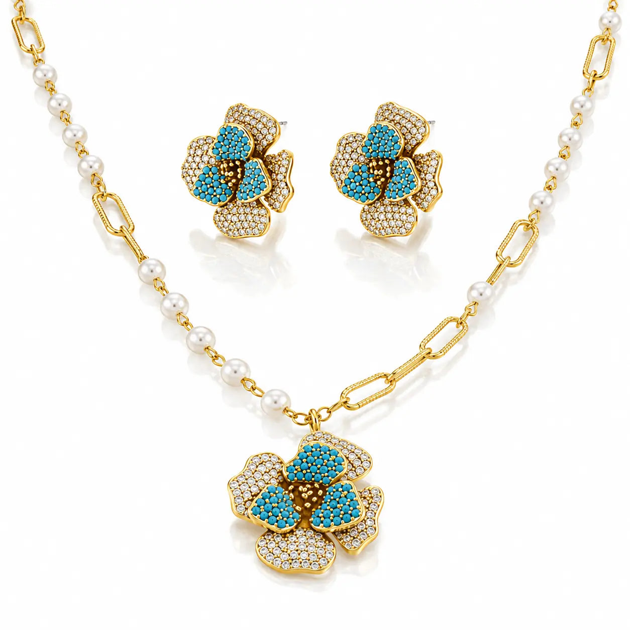 Gold-tone jewelry set with a pearl-and-link chain necklace, matching stud earrings, and a flower-shaped pendant. The flowers are accented with turquoise blue stones and pavé-set clear stones on a white background.
