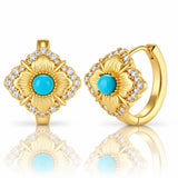 A pair of gold hoop earrings with a matching square flower-shaped front piece, featuring turquoise blue center stones surrounded by clear cubic zirconia accents, shown on a white background with a soft reflection.
