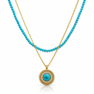A double-strand necklace featuring a turquoise and gold layered design. One strand consists of small, round turquoise beads on a gold chain, while the other is a delicate gold chain.
