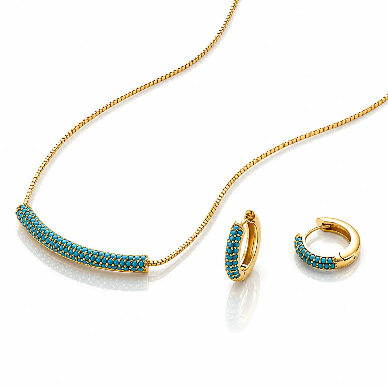 Gold jewelry set featuring a curved bar necklace and matching huggie hoop earrings, both adorned with a row of small turquoise-blue stones on a white background.