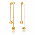 A pair of gold dangle earrings with spherical beads, shown on a clean white background with a subtle reflection below.
