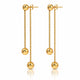 A pair of gold dangle earrings with spherical beads, shown on a clean white background with a subtle reflection below.