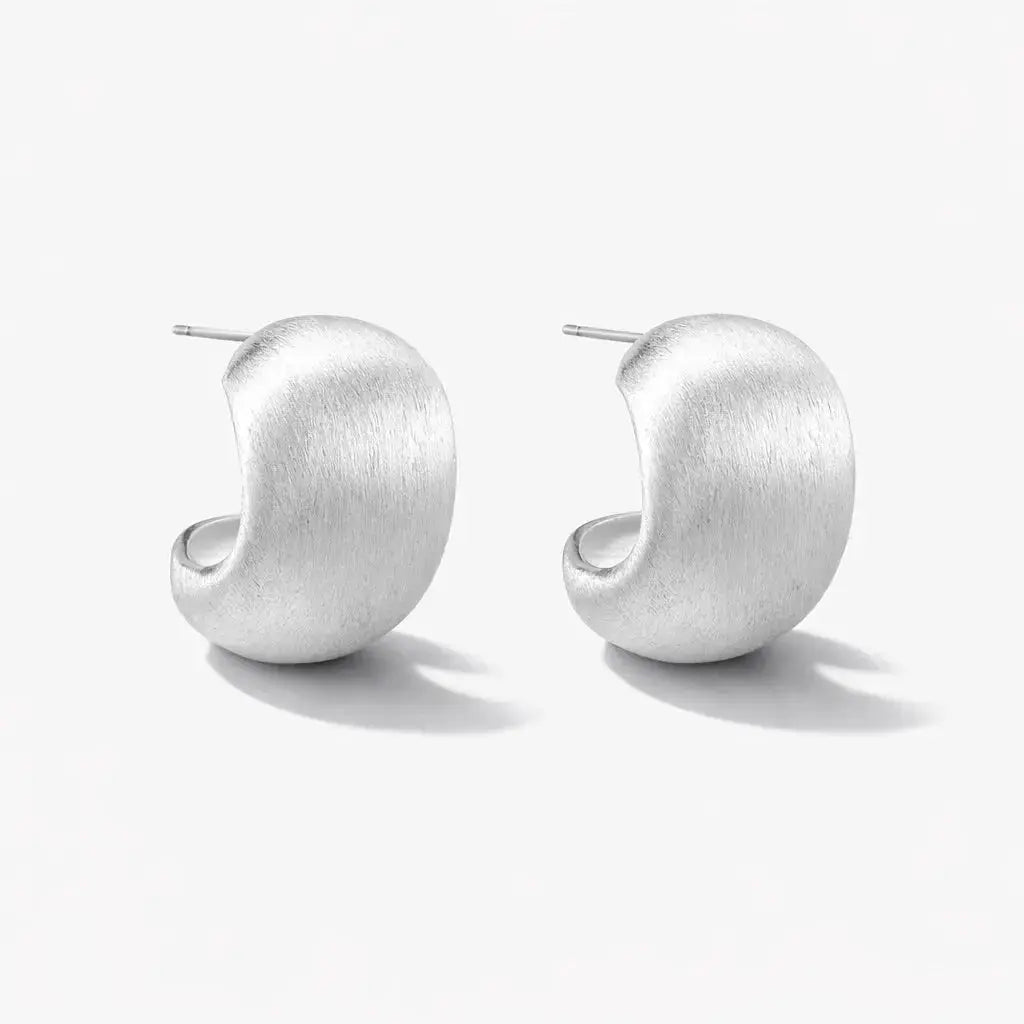 Pair of curved brushed silver stud earrings on a white background