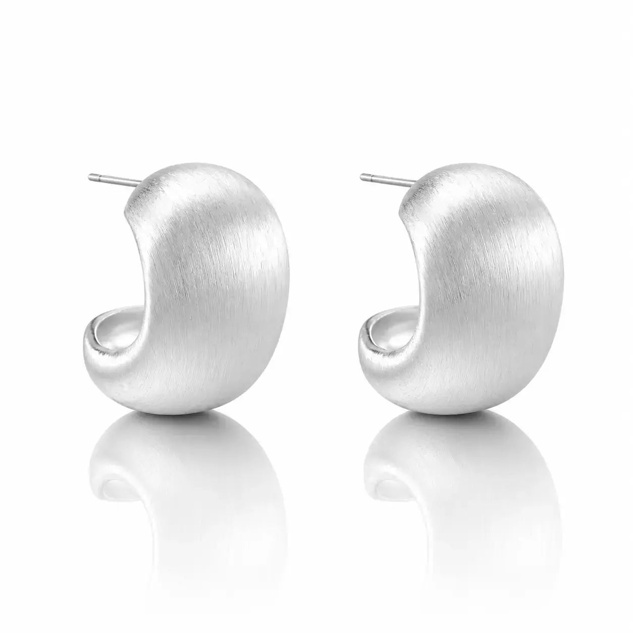 A pair of matte silver crescent-shaped hoop earrings with post backs, displayed on a clean white reflective surface.